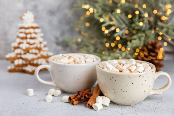 Hot drink with marshmallows and candy cane in  cup on a texture table.Cozy seasonal holidays.Hot cocoa with gingerbread Christmas cookies.Hot chocolate with marshmallow and spices.Copy space. - Photo, Image