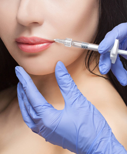 Lääkäri kosmetologi tekee Lip augmentation menettely kaunis nainen kauneushoitolassa.Kosmetologia ihonhoito. - Valokuva, kuva