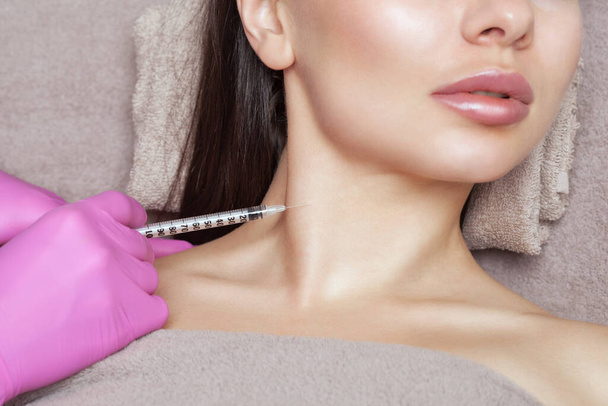 Kosmetologi tekee prp-terapiaa kauniin naisen kaulassa kauneushoitolassa.. - Valokuva, kuva