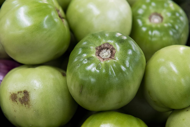 Piyasada yeşil ve kırmızı domates yığını. - Fotoğraf, Görsel