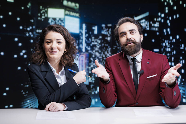 Newscasters team debating live topics on tv channel, broadcasting night show worldwide and discussing about latest news or interesting events. Man and woman colleagues working in media industry. - Photo, Image