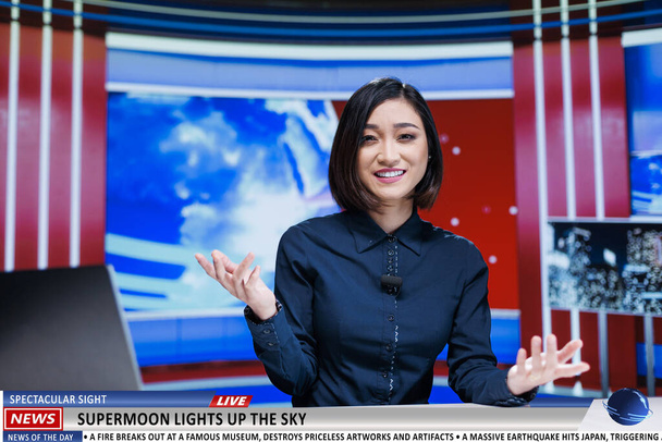 ニュースアンカーは,テレビでスーパームーン現象について話し,自然の巨大な月の夜空についての放送報道を作成します. ニュースルームのアジアの女性プレゼンター,魔法の天文学の光景. - 写真・画像