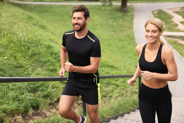 Healthy lifestyle. Happy couple running up stairs outdoors - Valokuva, kuva
