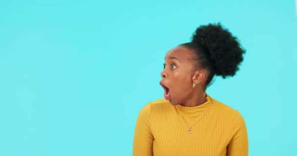 Mockup en gezicht van een zwarte vrouw op een blauwe achtergrond voor een retail deal of promotie. Verrassing, portret en een Afrikaans meisje of model met shock over een aankondiging met ruimte op de achtergrond. - Video