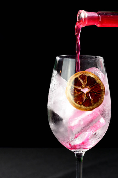 refrescante bebida alcohólica con frutas, vodka frío y ginebra, cáscara de limón servida en vaso de vidrio - Foto, imagen