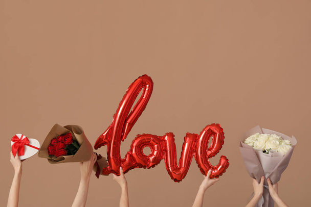 Ženy se slovem LÁSKA, dárky a růže na hnědém pozadí. Valentýnská oslava - Fotografie, Obrázek