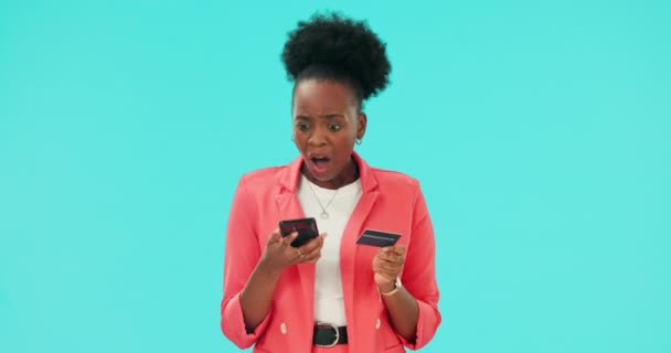 Woman, phone surprise and credit card for mistake, error or problem with e commerce, fintech or online payment fail. Stress and frustrated african person on mobile for debit on blue studio background. - Footage, Video