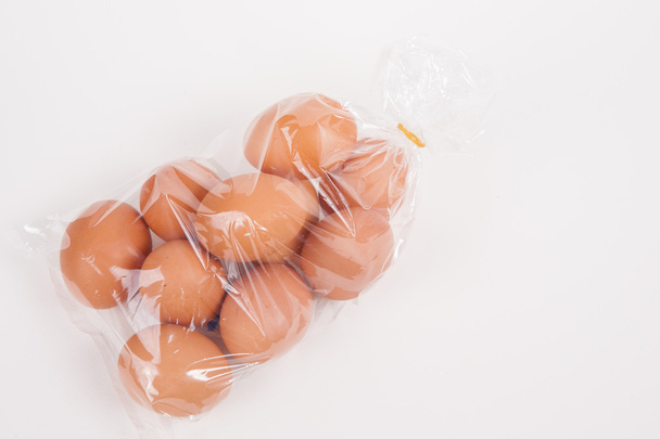 Eggs in a plastic bag on white paper background - Foto, afbeelding