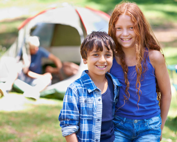 Camping, kids and happy in portrait while outside, bonding and carefree in outdoor adventure. Children, face and smiling together on holiday, friendship and vacation in nature, relaxing and grass. - Photo, Image