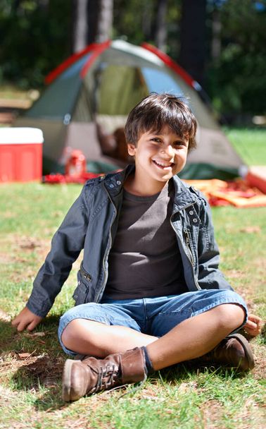 Relax, camping or portrait of happy child in nature for playing, adventure or holiday vacation in park. Grass, confidence or kid with smile in woods, garden or forest for fun hiking or childhood. - Photo, Image
