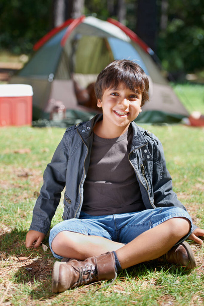 Relax, camping or portrait of happy kid in nature for playing, adventure or holiday vacation in park. Grass, confidence or male child with smile in woods, garden or forest for fun hiking or childhood. - Photo, Image