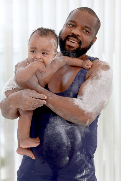 Happy African perhe, Isä tilalla söpö lapsi vauva lapsi kylvyn jälkeen ja soveltaa talkki jauhe kehon valmis kylpyhuoneessa. Isä huolehtii pikku söpö tytär lapsi perheessä. - Valokuva, kuva