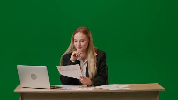 Brainstorming and problem solving concept. Portrait of female on chroma key green screen. Girl works with documents and laptop, lamp lights up over head. - Foto, imagen