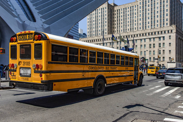 New York, USA; 1 juni 2023: De typische Noord-Amerikaanse gele schoolbus, die door de Big Apple rijdt en schoolkinderen vervoert. - Foto, afbeelding