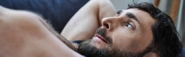 депресивний чоловік у повсякденному вбранні лежить на дивані під час розпаду, обізнаність про психічне здоров'я - Фото, зображення