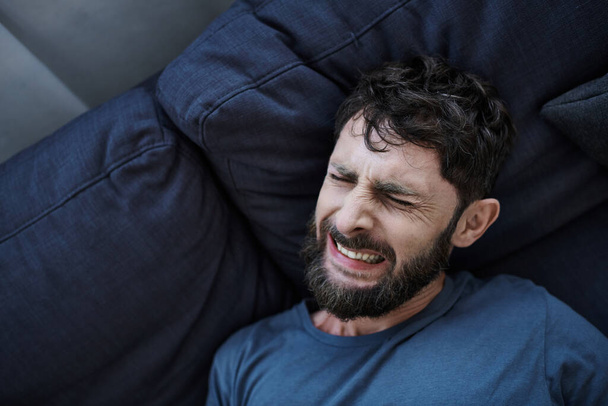 anxious man with beard in casual clothes suffering during breakdown, mental health awareness - Photo, Image