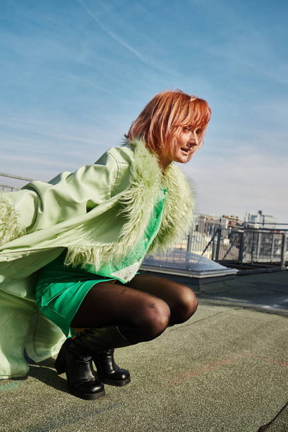 весела жінка мандрівник у стильному повсякденному вбранні, що сидить на гастролях на терасі на даху у Відні - Фото, зображення