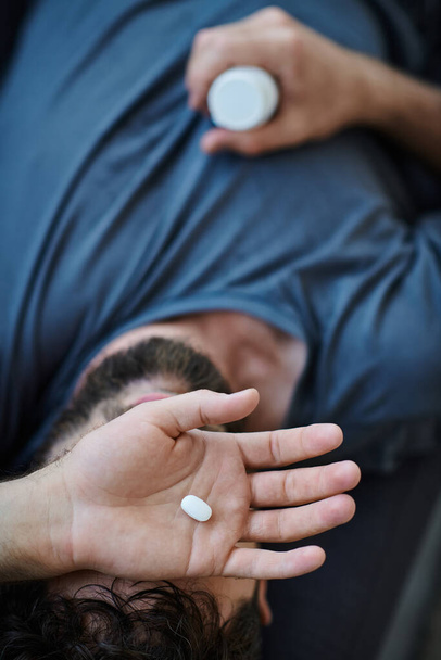Kranker depressiver Mann mit Bart nimmt während depressiver Episode Tabletten, Bewusstsein für psychische Gesundheit - Foto, Bild