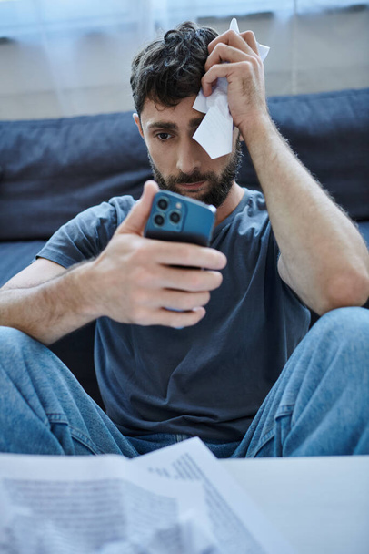 καταθλιπτικός άνθρωπος που υποφέρει κοιτάζοντας το smartphone του κατά τη διάρκεια καταθλιπτικών επεισοδίων, ψυχική υγεία - Φωτογραφία, εικόνα