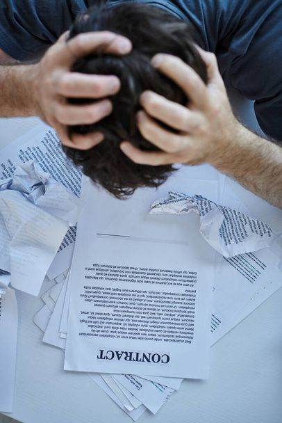 απελπισμένος άνθρωπος κοιτάζοντας τα χαρτιά του και το συμβόλαιό του κατά τη διάρκεια καταθλιπτικού επεισοδίου, ψυχική υγεία ευαισθητοποίηση - Φωτογραφία, εικόνα