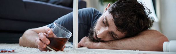 depressed man drinking alcohol and looking at pills during depressive episode, mental health, banner - Photo, Image