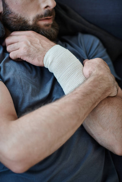visão cortada de homem deprimido com bandagem no braço depois de tentar suicídio, consciência de saúde mental - Foto, Imagem