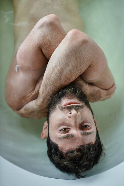 chory człowiek z urazem brodą leżący w wannie podczas załamania, świadomość zdrowia psychicznego - Zdjęcie, obraz