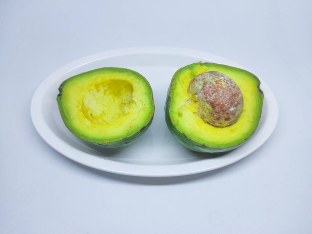 Half of Alpukat or Avocado (Persea americana), ripe and fresh, served in white plate - Photo, Image