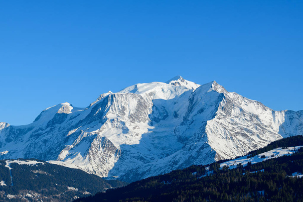 Esta foto de paisaje fue tomada en Europa, en Francia, en los Alpes del Ródano, en Saboya, en los Alpes, en invierno. Vemos los bosques y el macizo del Mont Blanc, bajo el sol. - Foto, Imagen