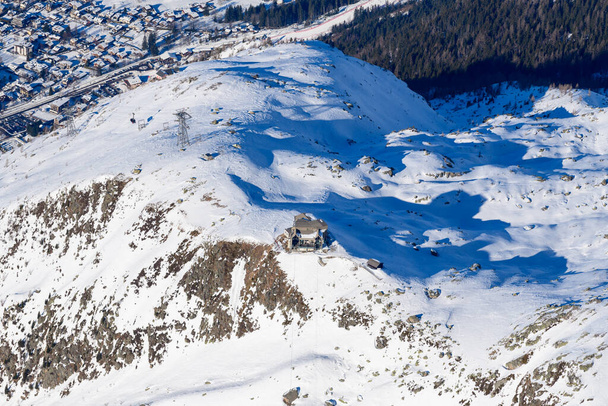 Esta foto de paisaje fue tomada en Europa, en Francia, en los Alpes del Ródano, en Saboya, en los Alpes, en invierno. Vemos la estación que conduce a la Aiguille du Midi en el macizo del Mont Blanc, bajo el sol. - Foto, Imagen