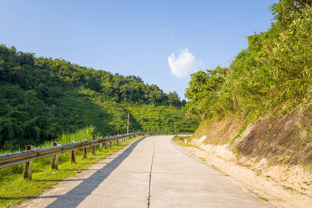 Esta foto de paisaje fue tomada, en Asia, en Vietnam, en Tonkin, en Dien Bien Phu, en verano. Vemos un camino en medio de las verdes montañas en el campo, bajo el sol. - Foto, Imagen