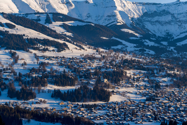 Esta foto de paisaje fue tomada en Europa, en Francia, en los Alpes del Ródano, en Saboya, en los Alpes, en invierno. Vemos la ciudad de Megeve en medio del macizo del Mont Blanc, bajo el sol. - Foto, imagen