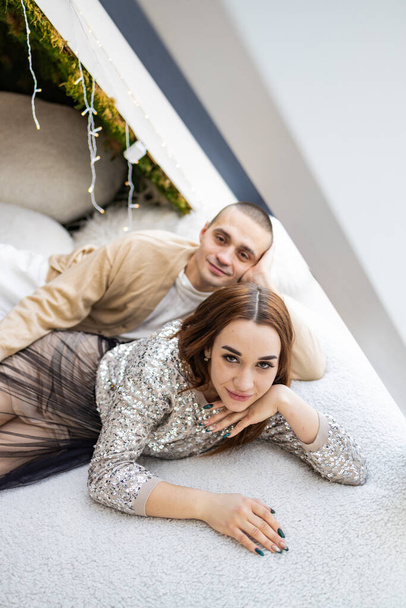 Romantic couple in love feeling happiness from their romance while spending Christmas together, woman and man enjoying perfect relationship and spending winter holidays in cozy home interior - Photo, Image