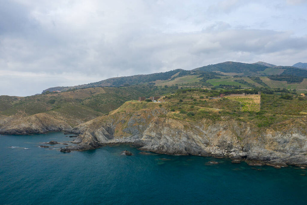 This landscape photo was taken in Europe, in France, in Occitanie, in the Pyrenees Orientales, in Banyuls-sur-Mer, At the edge of the Mediterranean Sea, in summer. We see the arid rocky coast, under the Sun. - Photo, Image
