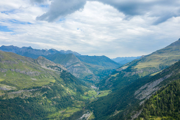 Esta foto de paisagem foi tirada, na Europa, na França, Occitanie, nos Pirinéus Hautes, no verão. Vemos o vale de Gavarnie no meio das montanhas e sua paisagem verde, sob o sol. - Foto, Imagem
