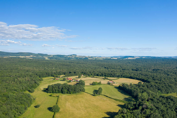 Questa foto paesaggistica è stata scattata in Europa, in Francia, in Borgogna, a Nievre, vicino a Chateau Chinon, in estate. Vediamo la verde campagna con le sue foreste e campi, sotto il sole. - Foto, immagini