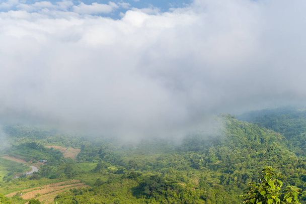Esta foto de paisaje fue tomada, en Asia, en Vietnam, en Tonkin, en Dien Bien Phu, en verano. Vemos las nubes sobre la ciudad vistas en las verdes montañas, bajo el sol. - Foto, Imagen