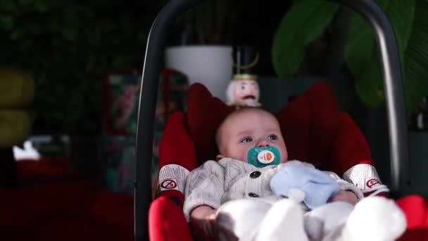 close-up van pasgeboren baby meisje in autostoel thuis. - Video