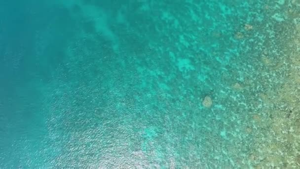 Luchtfoto van turquoise oppervlak van de zee en de schittering van de zon. Transparante oceaanwateroppervlakte. - Video