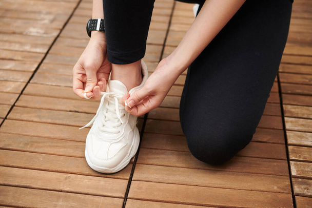 Zbliżenie kobiecych sznurówek do butów do biegania przed treningiem - Zdjęcie, obraz
