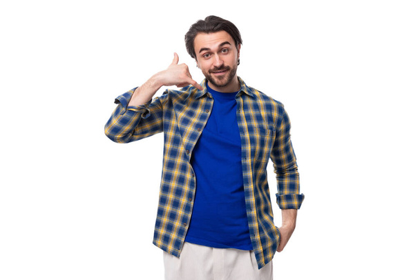 ハンサム ブルネット マチョ 男 ととも に 青い シャツ に 白い 背景 積極的に コピー スペース 彼の 手 で ジェスチャー. - 写真・画像