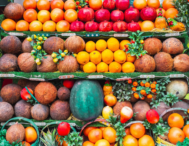 フルーツは地元の農家市場でさまざまな種類の果物とスタンドします. エキゾチックでユニークなフルーツ,新鮮な食品市場の大きな選択. さまざまな種類の新鮮なフルーツがきちんと整理されています. ココナッツ, オレンジ, ポメラネート - 写真・画像