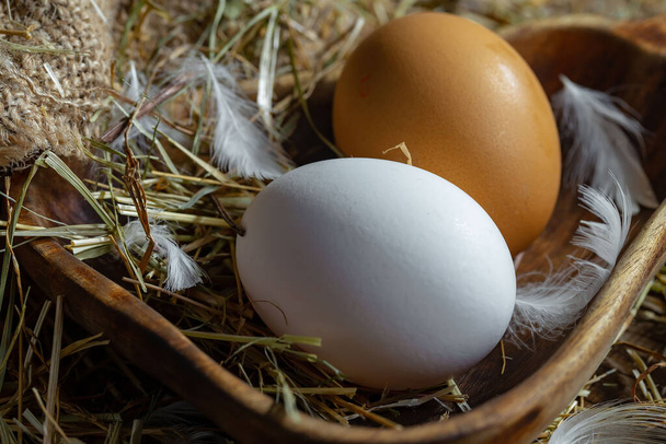 Αυγά κοτόπουλου, ωμά, στο φόντο του ξηρού χόρτου - Φωτογραφία, εικόνα