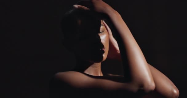 Πρόσωπο, χέρια και δέρμα με μια φυσική μαύρη γυναίκα σε σκούρο φόντο στο στούντιο για γυναικεία ευεξία. Πορτρέτο, ομορφιά και spa με ένα τρυφερό νεαρό μοντέλο που αγγίζει το σώμα της στην ικανοποίηση από την περιποίηση της επιδερμίδας. - Πλάνα, βίντεο