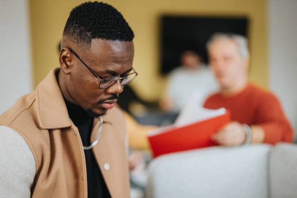 Goed uitziende, zwarte man die rapporten leest op het werk terwijl hij in een modern kantoor staat. Kopieerruimte. - Foto, afbeelding