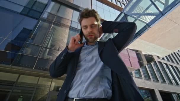 Hombre de negocios estresado llamando al celular en el exterior del centro de negocios. Empresario molesto teniendo conversación nerviosa del teléfono móvil en la calle de la ciudad. Jefe preocupado sintiéndose insatisfecho hablando emocionalmente - Imágenes, Vídeo