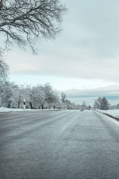 Glace sur la route. Route glissante. Arbres dans la neige le long de la route. La circulation routière en hiver.Hiver beau paysage.Danger de routes en hiver  - Photo, image