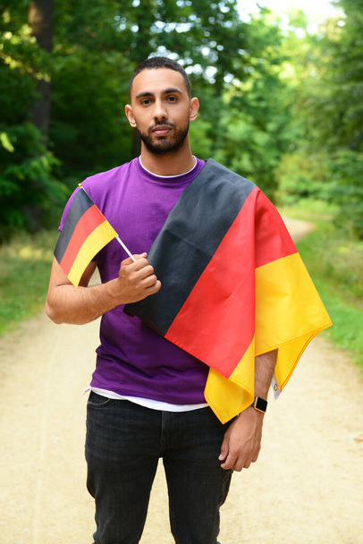 Almanya bayraklı genç adam ormanda - Fotoğraf, Görsel