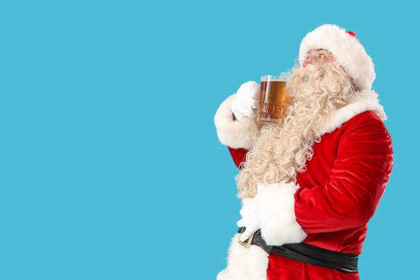 Santa Claus with mug of beer on blue background - Photo, Image
