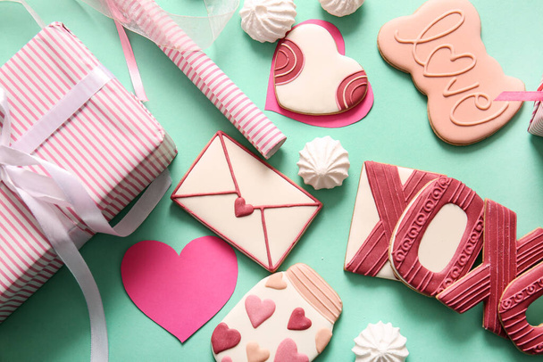 Dolci biscotti con meringa e regalo su sfondo turchese. Festa di San Valentino - Foto, immagini